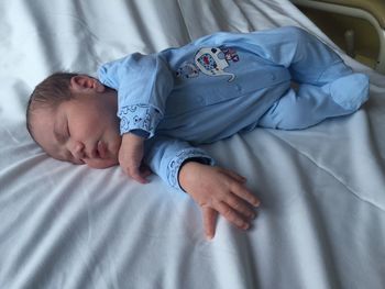 High angle view of newborn baby lying on bed