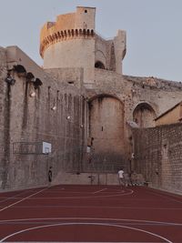 Boys playing basketball in old historic building