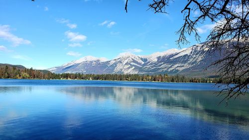 Scenic view of lake and mountains against blue sky