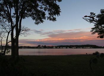 Scenic view of river against sky at sunset