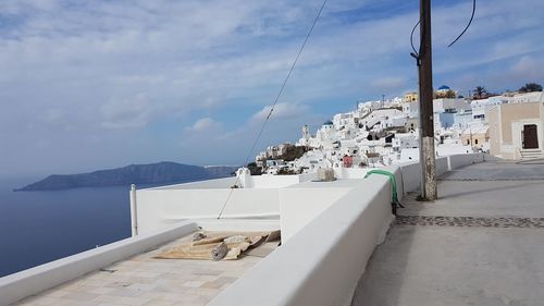 Panoramic view of sea and buildings in town against sky