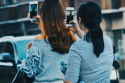 Rear view of woman photographing