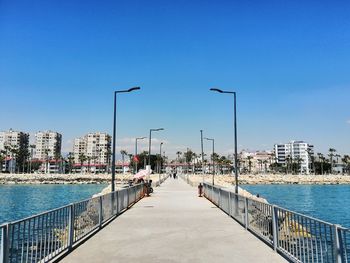 City street by sea against clear blue sky