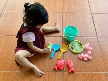 High angle view of girl playing with toy on floor