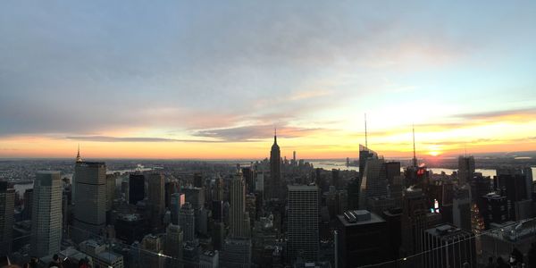 Aerial view of buildings against cloudy sky during sunset