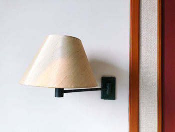 Close-up of lamp against white wall