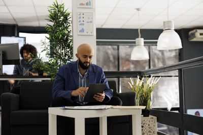 Side view of man using laptop while sitting in cafe