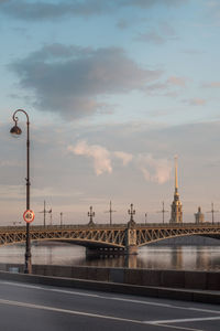 View of bridge over street against cloudy sky