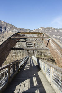 Empty footbridge against clear sky