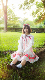 Portrait of a smiling young woman sitting on field