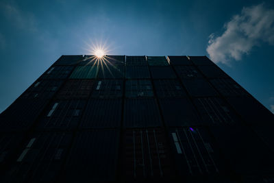  shipping container with sun flair light blue sky  wide angle view shot darkened shadow tone