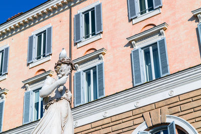 Low angle view of statue against building in city