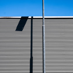 Low angle view of building and shadow against clear sky