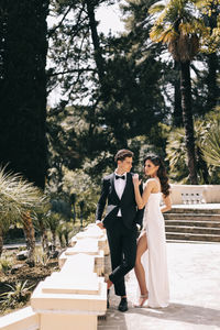 A beautiful couple in love, bride and groom in wedding clothes, walk and pose in the park in nature