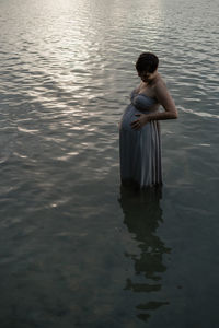 Rear view of woman standing in lake