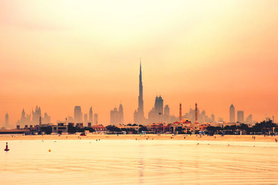 City buildings at waterfront during sunset