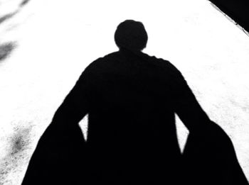 Rear view of silhouette man standing against wall