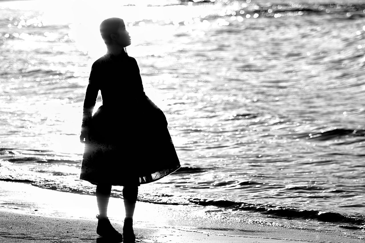 REAR VIEW OF SILHOUETTE WOMAN LOOKING AT SEA