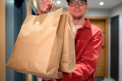 Midsection of woman holding shopping bags