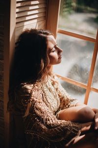 Woman sitting by window at home