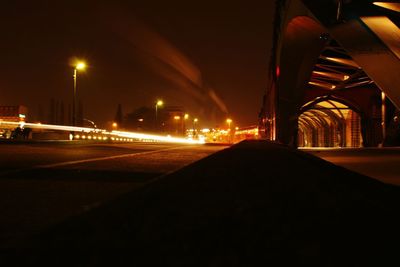 Illuminated road against sky in city at night