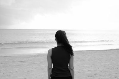 Rear view of man looking at sea against sky