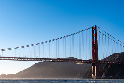 View of suspension bridge against blue sky