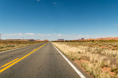 An empty road going towards some mountains on the horizon and almost with no clouds. arizona, usa