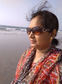 Portrait of woman wearing sunglasses at beach