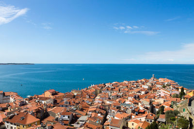 High angle view of townscape by sea against sky