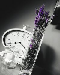 Close-up of purple flowering plants in glass vase on table