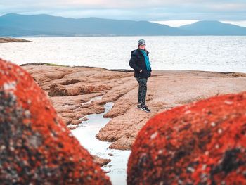 Full length of man standing on rock at beach