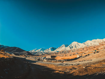 Scenic view of snowcapped mountains against clear blue sky