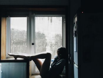 Man sitting on window at home