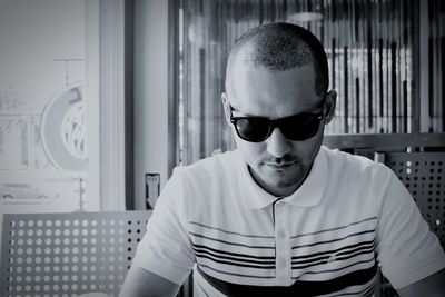 Mid adult man wearing sunglasses while sitting on chair