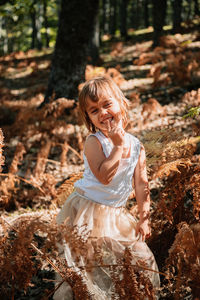 Portrait of cute girl standing in forest