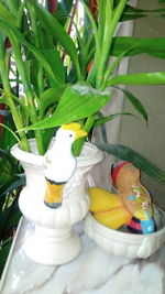 Close-up of figurine with toys on plant