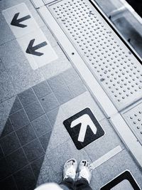 Low section of man standing on tiled floor