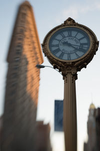 Low angle view of clock tower against sky in city