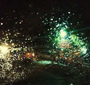 Illuminated city seen through wet glass
