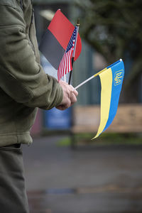 Midsection of man holding flag