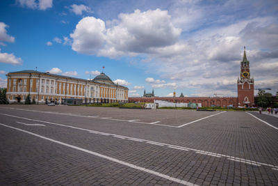 Buildings in city against cloudy sky