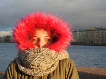 Portrait of girl against river and sky during winter