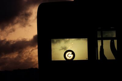 Low angle view of illuminated lamp against sky at sunset
