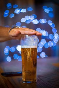 Beer glass with hand and bokeh