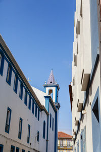 Low angle view of buildings against clear blue sky