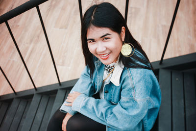 High angle portrait of young woman sitting on steps