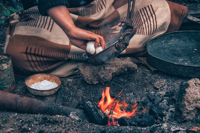 Low section of man sitting on barbecue grill