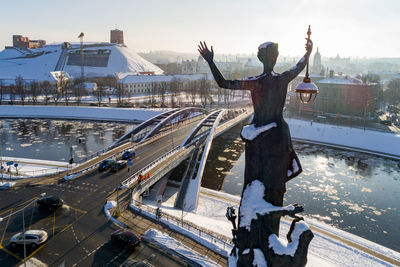 Statue in city against sky during winter