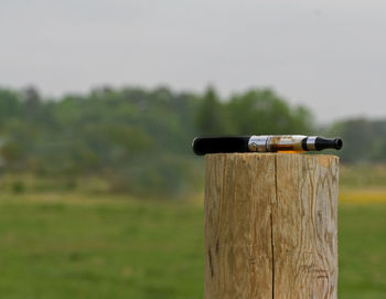 Close-up of wooden post on field